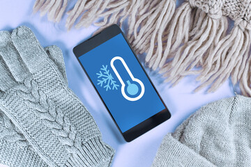 Concept for cold temperatures with snow and minus degrees with mobile phone showing weather...