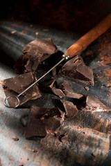 Dark chocolate chunks whit filtered light on black background