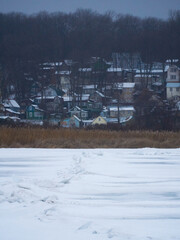 Houses of a fishing village on the banks of the frozen Voronezh reservoir in winter