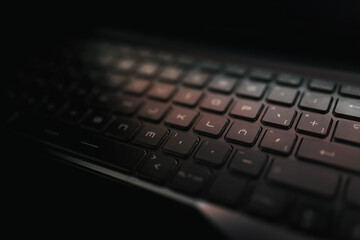Spanish laptop keyboard illuminated by the screen in the dark. Spanish letter "Ñ". Spanish language and literature concept.