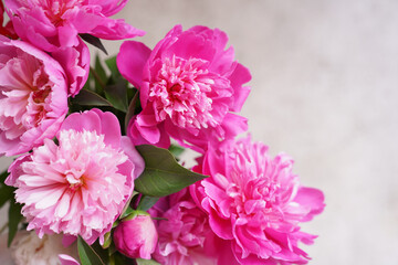 Bouquet of pink peonies on a beige picturesque background with a copy space