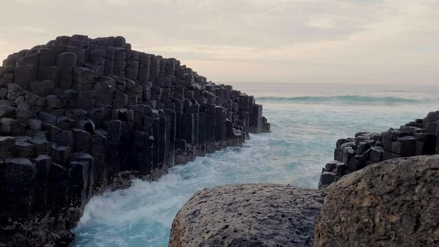 Fisherman on Giants Causeway at sunrise with red ball of the sun and nice clouds