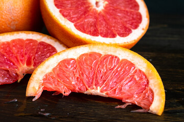 Red Grapefruit Sliced into Wedges: A pink grapefruit sliced in half and into smaller wedges
