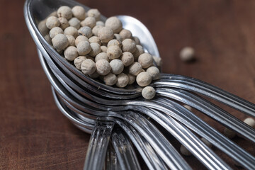 Fototapeta na wymiar white pepper seeds in a row of spoons