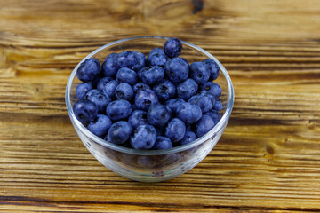 Fresh blueberry in glass bowl on a wooden table