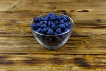 Fresh blueberry in glass bowl on a wooden table