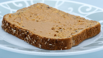 Peanut butter on a slice of brown bread with shallow depth of field