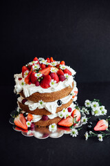 Wedding cake with strawberries on dark background
