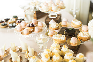Delicious and tasty dessert table with cupcakes and shots at reception closeup