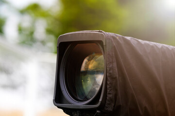 Television broadcast camera shooting at a sunny football game