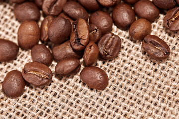 Close-up of roasted coffee beans on Hessian burlap with a copy of the space for your text.