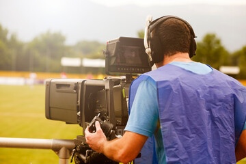 Television broadcast camera shooting at a sunny football game