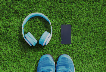 Close up sneakers with wireless headphones and phone on a grass background