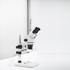 Nowoczesny biały mikroskop stojący na biurku w sterylnym laboratorium - obrazy, fototapety, plakaty