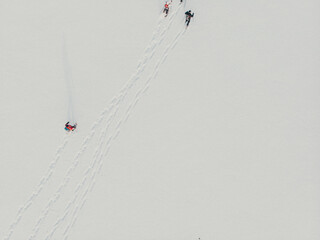 Aerial. Snowshoe walker. Outdoor winter activity and healthy lifestyle. Winter sport activity. Woman hiker hiking with backpack and snowshoes snowshoeing on snow trail forest at sunset