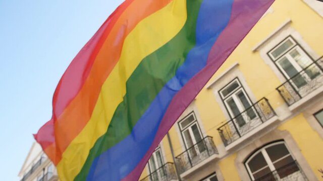 holding big rainbow flag in parade slow motion