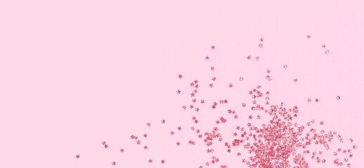 Naklejka premium scattered pink holographic glitter confetti star shaped on candy pink background Flat lay top view. Festive holiday pastel backdrop. Birthday, Christmas, New Year Valentines Day banner. copy space