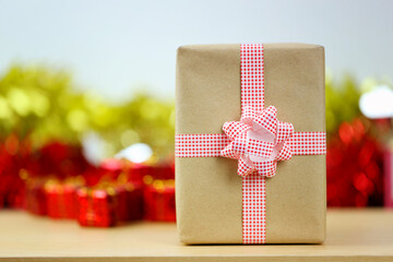 A brown gift box is placed on a table with festive decorations item.