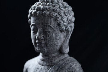 Meditating Buddha Statue isolated on black background. Copy space.