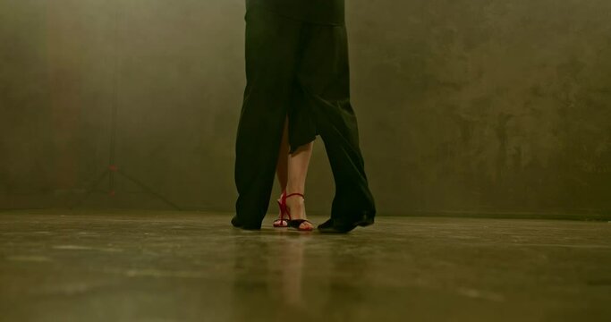 Close-up, man and woman feet dancing, dancing on the dark floor. Beautiful dance moves in a dark room. 4k, ProRes
