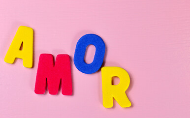 Love, amor, te amo lettering on pink background, yellow red blue green letters on romance Saint Valentine, wedding, birthday, date, dating card. 