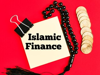 Text Islamic Finance on paper note with prayer beads and coins isolated on red background. Islamic...