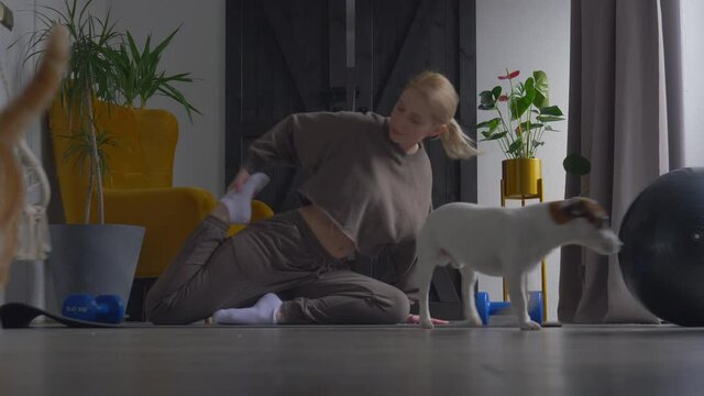 girl doing meditation on the rug at home next to the dog