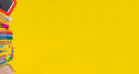 Set of school items on the left of the orange background. Back to school concept. Top view. Banner. Copy space