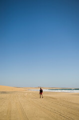 Fototapeta na wymiar Hombre solo caminando en la playa 