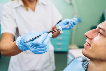 Close-up of the dentist's hands with medical devices. Large detail - dentist's mirror, curling and probe. Resolving dental problems effectively with confident, professional gestures