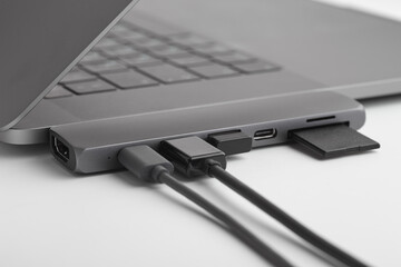 Close-up photo of type-c hub with cables and card connected to laptop