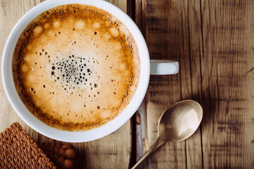 Delicious cappuccino on wooden table