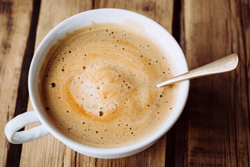 Delicious cappuccino on wooden table