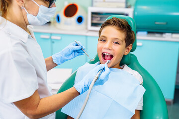 Patient with open mouth in dental clinic. Preparation for dental treatment. Using cotton wool to collect saliva, bor machine, dental mirror, tweezers and other devices. Timely treatment is important