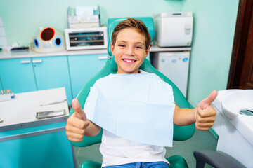 Small, young patient boy is happy with a visit to the dentist. Concept of painless dental...