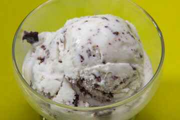 Ice cream cookies and cream in a bowl on a yellow background. Seletive focus.