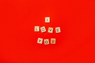Wooden plaque with the text I love you on a red background. Composition Valentine's Day. Banner....