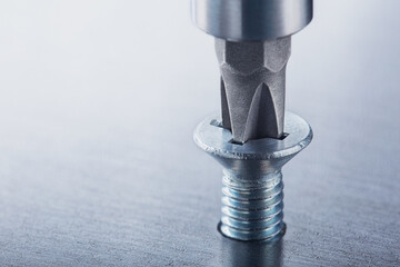 Screwdriver screw in metal steel plate bolt. Spanner, bolt, screw and nuts.