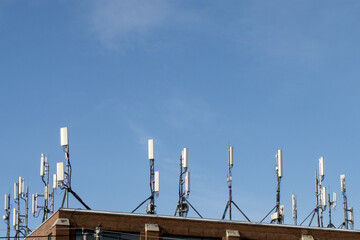 an array of cell phone antennae on a building in a city