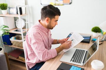 Attractive guy reviewing some work documents in his office