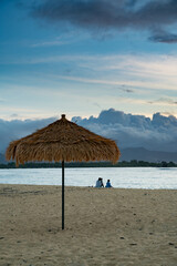 Mornings at a Hawaiian beach, people silhouetted, fishing, walking stretching.