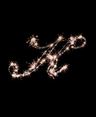 the letter k made from sparks of Bengal lights isolated on a black background.
