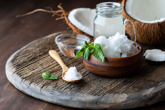 Close up of coconut oil with coconut MTC oil and coconut water all on a wooden board.