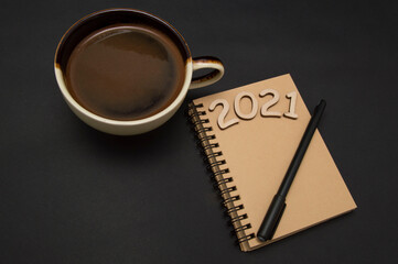 Close up of 2021 calendar and coffee cup on black background.happy new year