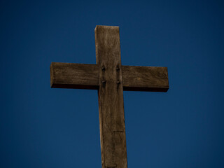 Cruz de madera con el cielo azul al fondo.