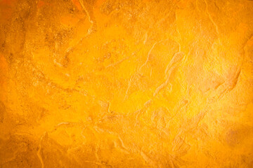 Gold stone texture background. Gold or foil wall texture backdrop design. Walls are decorated with gold-colored filters. Cement orange wall background. gold color wall for the background.