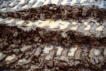 tyre tracks in the mud. Mud with a puddle and traces of transport on an impassable road