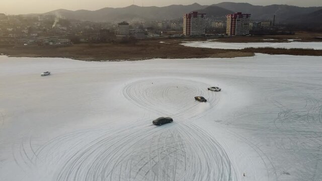 Three cars drift parallel on ice in Russia