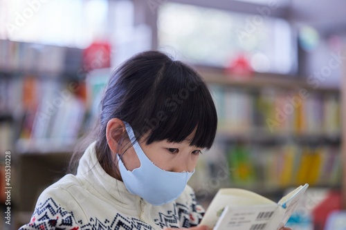 図書館で真剣に本を読む小学生の女の子の姿 Wall Mural Zheng Qiang