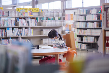 図書館で読書している小学生の女の子の姿